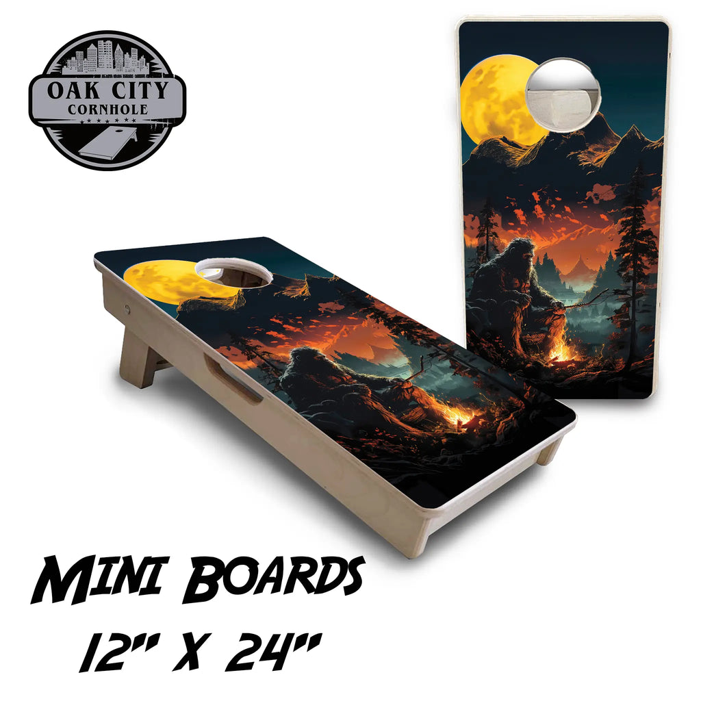 Premium handcrafted 24x48 cornhole boards featuring a 'Bigfoots Campfire' design from Oak City Cornhole. Perfect for tournaments with a high-resolution image of Bigfoot by a campfire in the woods.